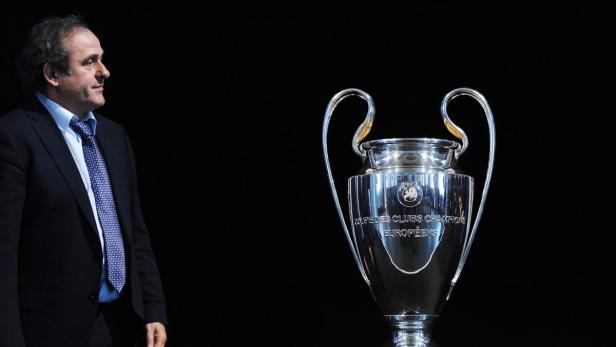 Michel Platini steht neben der Trophäe der UEFA Champions League.