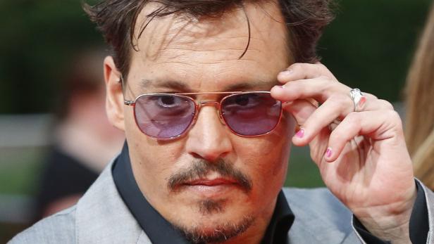 Johnny Depp mit rosa lackierten Fingernägeln und einer Pilotenbrille.