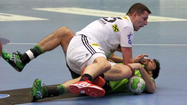 Zwei Handballspieler kämpfen am Boden um den Ball.
