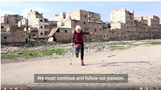 Mädchen mit Unterschenkel-Prothese und Krücke spielt Fußball im kriegszerstörten Aleppo