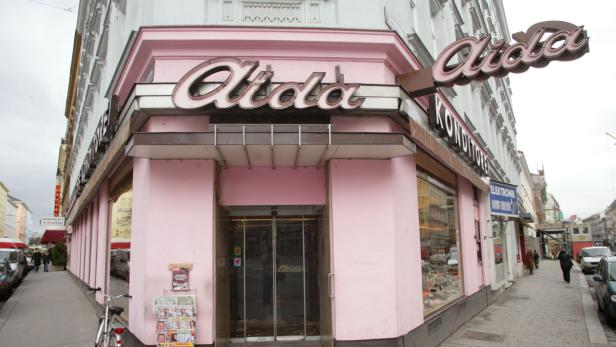 Das rosa Gebäude der Konditorei Aida in einer Stadt.