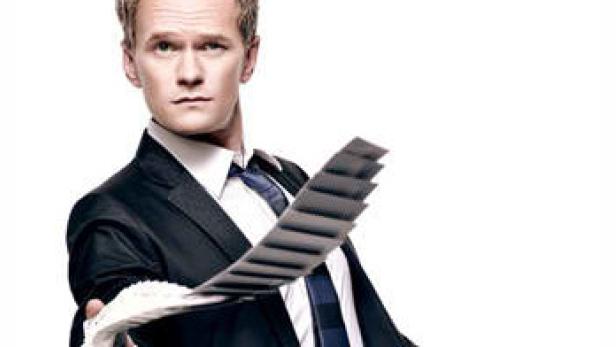 Neil Patrick Harris im Anzug hält eine Hand voller Karten in die Kamera.