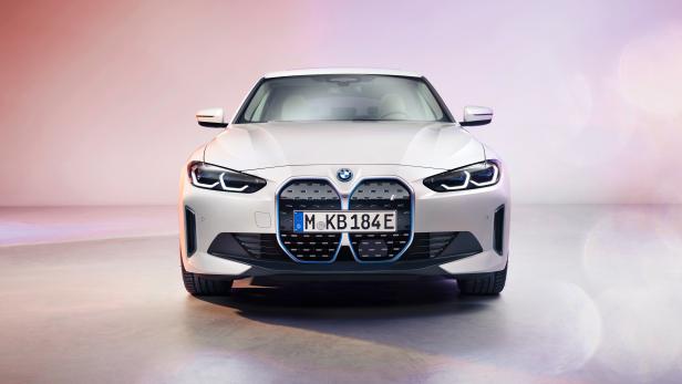 Ein weißer BMW i4 von vorne in einem Studio.