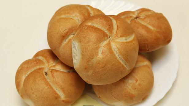 Fünf Kaisersemmeln liegen auf einem weißen Teller.