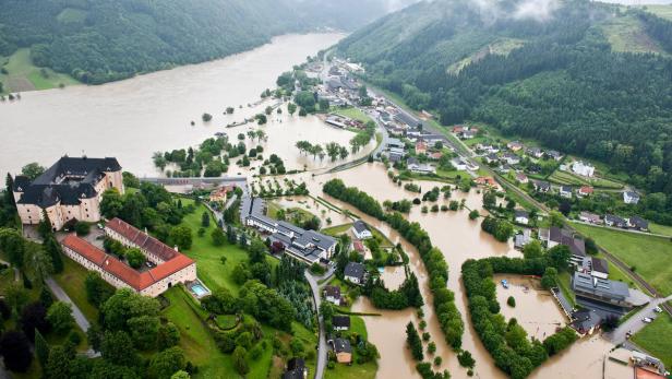 Luftaufnahme von Schloss Traun und der überfluteten Stadt Traun in Österreich.