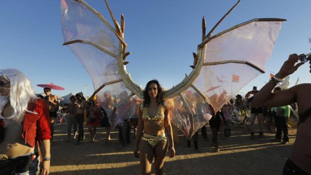 epa03687471 Participants in the AfrikaBurn festival do a bare breast parade in the Karoo desert, Tweefontein, South Africa, 04 May 2013. The festival is based on Burning Man in the United States and sees thousands of people gathering in the desert to construct a temporary community. The event is part rave, part trance party, part Pagan gathering, part arts festival as thousands of participants erect art pieces, share ideas, and burn effigies on the final night. There must be no trace of humans after the event is finished and a sharing community is formed as there is no money allowed as participants have to bring their own food, water and tents. EPA/KIM LUDBROOK