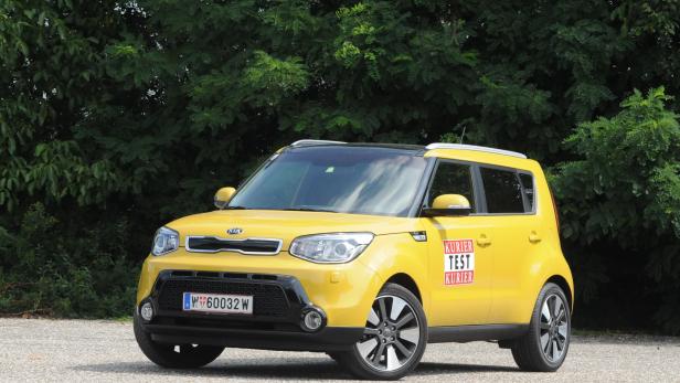 Ein gelber Kia Soul steht vor einem grünen Hintergrund.