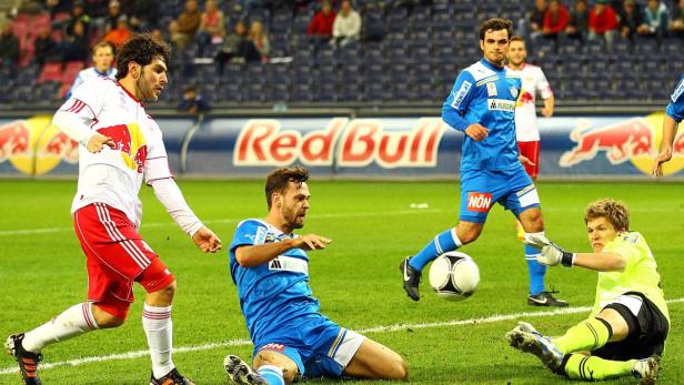 Ein Fußballspiel mit Spielern in blauen und roten Trikots in Aktion.