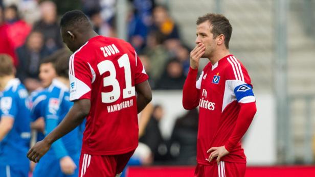 Zwei Fußballspieler des Hamburger SV in roten Trikots auf dem Spielfeld.