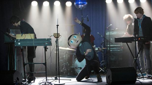 Der Mann mit dem Pappmaché-Kopf ist Michael Fassbender und singt live als genial-exzentrischer Frontman einer Band: „Frank“.