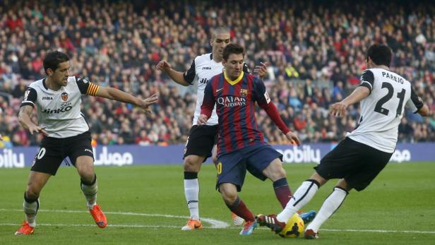 Lionel Messi während eines Fußballspiels mit Gegenspielern.