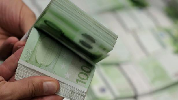 Eine Hand hält einen Stapel von 100-Euro-Scheinen.