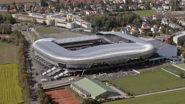 Luftaufnahme eines modernen Stadions in einer städtischen Umgebung.