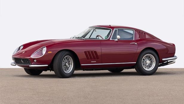Ein burgunderroter Ferrari 275 GTB steht auf einer Betonfläche.