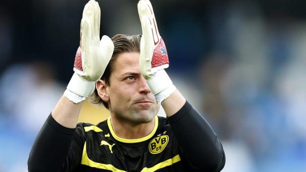 Ein Torwart von Borussia Dortmund winkt mit seinen Torwarthandschuhen.