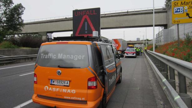 Ein ASFINAG-Fahrzeug mit einer digitalen Anzeige „Unfall“ steht auf einer Autobahn.