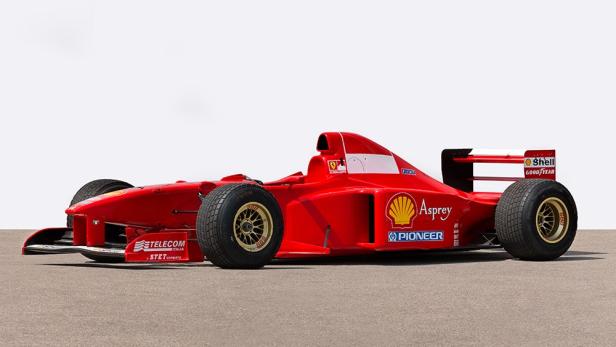 Ein roter Ferrari-Formel-1-Rennwagen steht auf einer grauen Oberfläche.