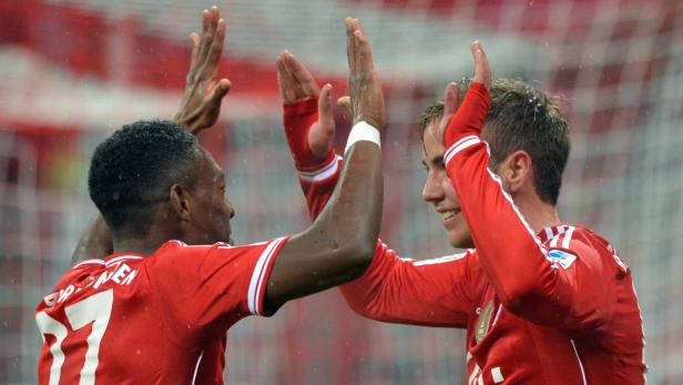 Zwei Fußballspieler in roten Trikots geben sich ein High-Five.