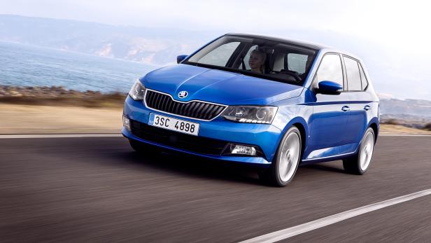 Ein blauer Škoda Fabia fährt auf einer Küstenstraße.