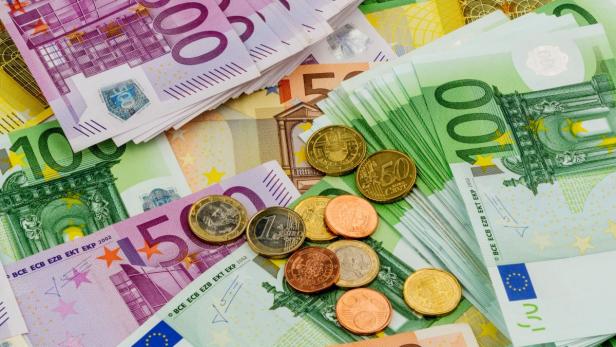 Verschiedene Euro-Banknoten und -Münzen liegen übereinander.