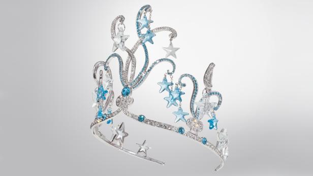 Eine silberne Tiara mit blauen und weißen Sternen und Strasssteinen verziert.