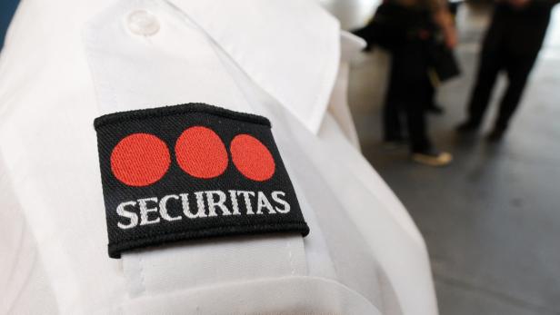 Das Abzeichen des Sicherheitsdienstes Securitas auf dem Hemd eines Mitarbeiters.