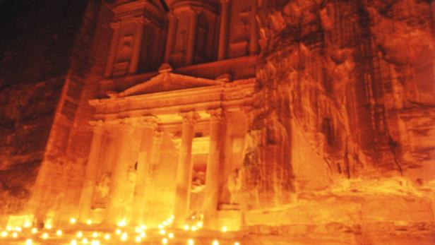 Das Schatzhaus in Petra, Jordanien, ist nachts von Kerzen beleuchtet.