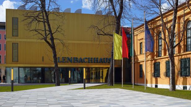 Das Lenbachhaus in München mit bunten Flaggen im Vordergrund.