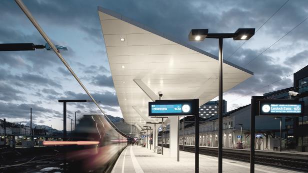 Ein Zug fährt in den Bahnhof ein, Abfahrt in Freilassing um 16:42.