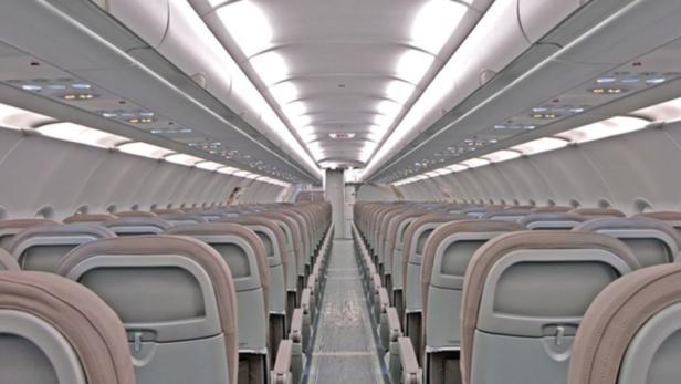 Blick in den Gang eines leeren Passagierflugzeugs.