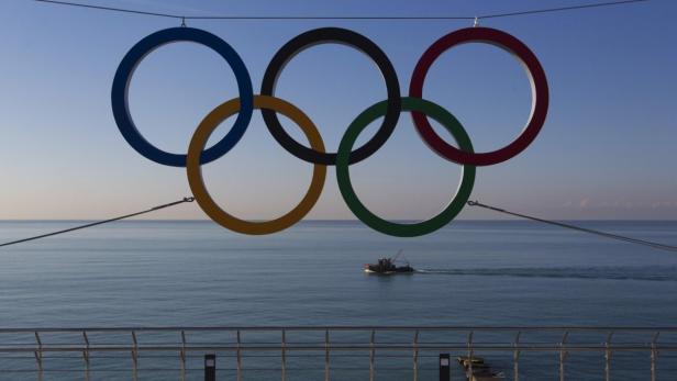 Die olympischen Ringe hängen vor dem Hintergrund des Meeres.
