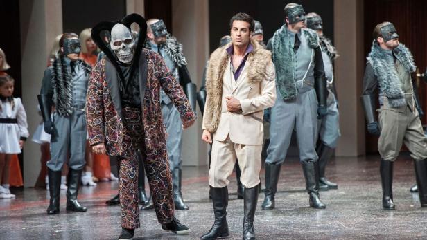 Rame Lahaj als Herzog (Mitte) und Ivan Inverardi als Rigoletto (links mit Maske): Das kalte Bühnenbild  stammt von Alexander Müller-Elmau. Kostüme: Kirsten Dephoff.