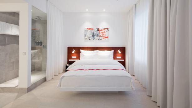 Schlanker Luxus: In den Zimmern finden sich Holzwandvertäfelung, Luxus-Bett und -dusche.