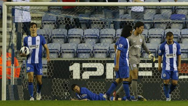 Wigan Athletic&#039;s player reacts after Swansea City scored a third goal during their English Premier League soccer match at The DW Stadium in Wigan, northern England May 7, 2013. REUTERS/Phil Noble (BRITAIN - Tags: SPORT SOCCER) FOR EDITORIAL USE ONLY. NOT FOR SALE FOR MARKETING OR ADVERTISING CAMPAIGNS. NO USE WITH UNAUTHORIZED AUDIO, VIDEO, DATA, FIXTURE LISTS, CLUB/LEAGUE LOGOS OR &quot;LIVE&quot; SERVICES. ONLINE IN-MATCH USE LIMITED TO 45 IMAGES, NO VIDEO EMULATION. NO USE IN BETTING, GAMES OR SINGLE CLUB/LEAGUE/PLAYER PUBLICATIONS