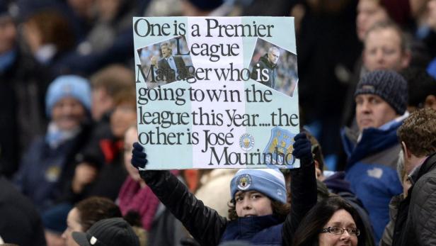 A fan holds up a placard before the English Premie