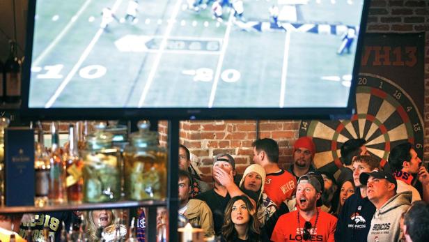 Broncos fans react to a play while watching their