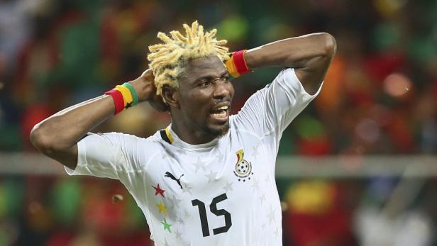 Ein Fußballspieler mit blond gefärbten Dreadlocks in einem weißen Trikot hält die Hände an den Kopf.