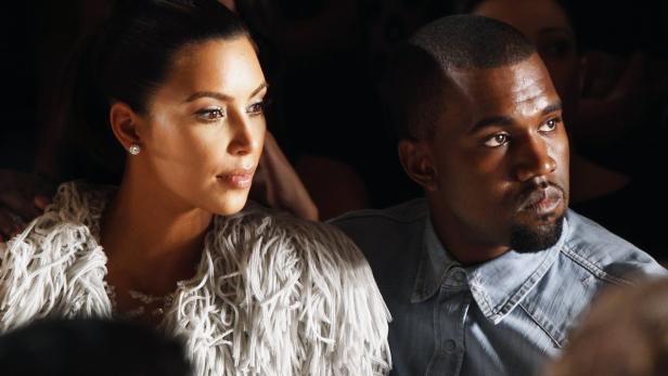 West drapes his arm over the shoulder of Kardashia
