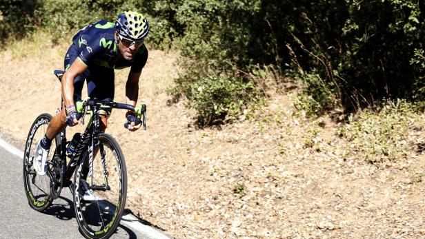 Ein Radfahrer fährt auf einer asphaltierten Straße bergauf.