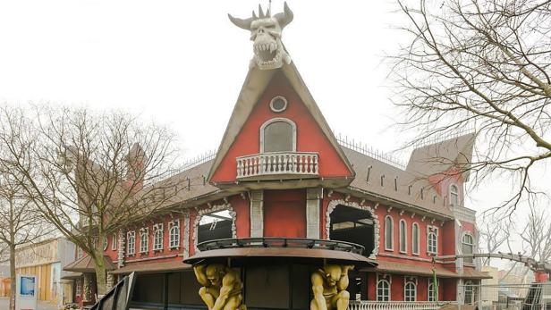 Ein rotes Gebäude mit einem großen Totenkopf mit Hörnern auf dem Dach.