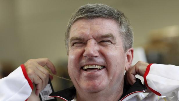 Ein Mann mit geschlossenen Augen und einem breiten Lächeln hält ein Preisschild in der Hand.