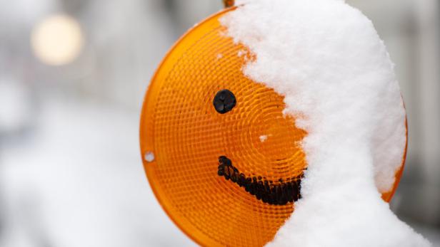 Ein Smiley ist am 07.12.2012 auf einem Baustellenwarnlicht, das von Schnee bedeckt ist, in Köln (Nordrhein-Westfalen) zu sehen. Foto: Rolf Vennenbernd/dpa +++(c) dpa - Bildfunk+++