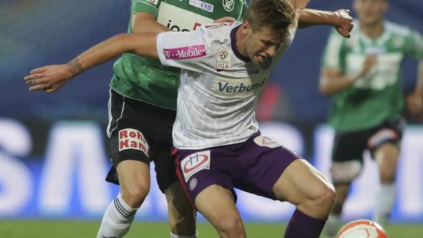 Zwei Fußballspieler kämpfen um den Ball während eines Spiels.