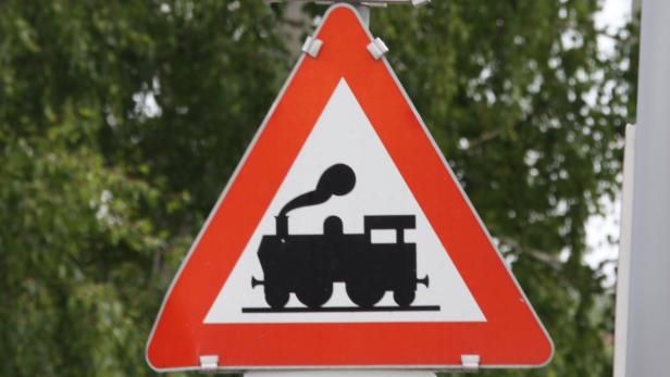 Ein dreieckiges Warnschild mit dem Symbol einer Dampflokomotive.