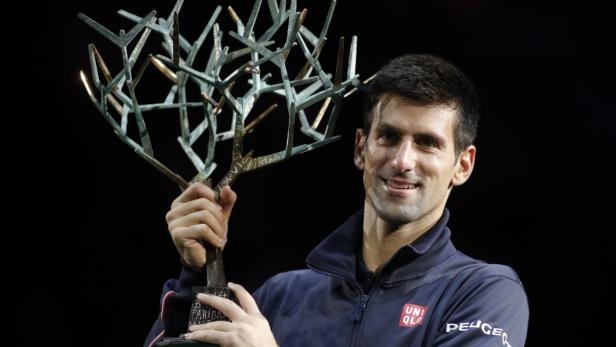 Novak Đoković hält eine Trophäe in Form eines Baumes.