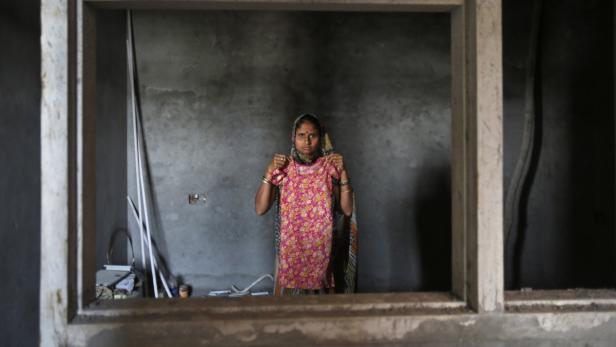 Mamta, 32, poses with a dress belonging to her missing seven-year-old daughter Bharti inside her makeshift shelter in New Delhi April 27, 2013. According to Mamta, her daughter went missing on April 18, 2013, from a construction site where Mamta works and lives. Between January 1 and May 8, 2013, 725 children in Delhi were reported missing and are untraced, according to data from India&#039;s Zonal Integrated Police Network website. Picture taken April 27, 2013. REUTERS/Mansi Thapliyal (INDIA - Tags: SOCIETY CRIME LAW) ATTENTION EDITORS: PICTURE 10 of 17 FOR PACKAGE &#039;INDIA&#039;S MISSING CHILDREN&#039; SEARCH &#039;DELHI CHILDREN&#039; FOR ALL IMAGES