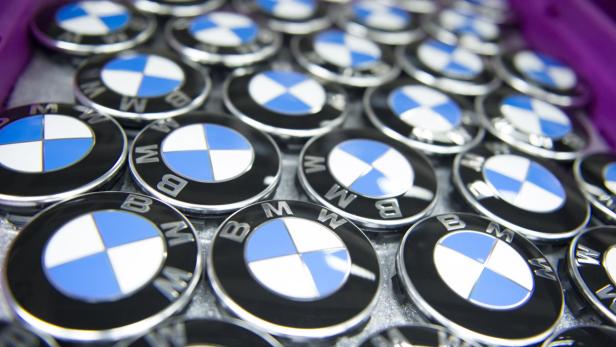 Viele BMW-Embleme liegen in einer lila Kiste.