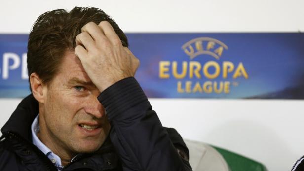 Ein Mann mit sorgenvollem Gesichtsausdruck vor einem Europa League-Hintergrund.