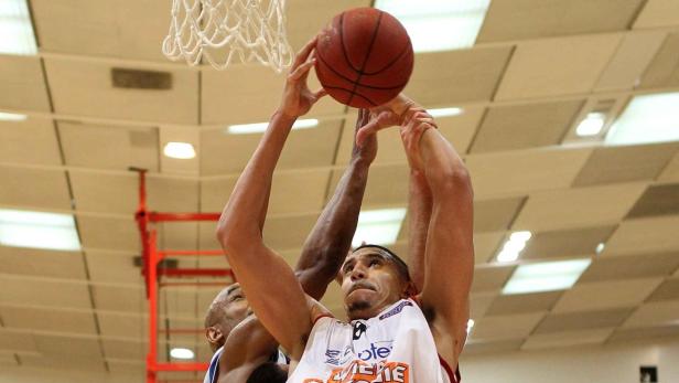 Ein Basketballspieler versucht, den Ball in den Korb zu werfen.