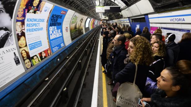 Menschen warten auf der Bahnsteigebene der Londoner U-Bahn-Station Victoria.